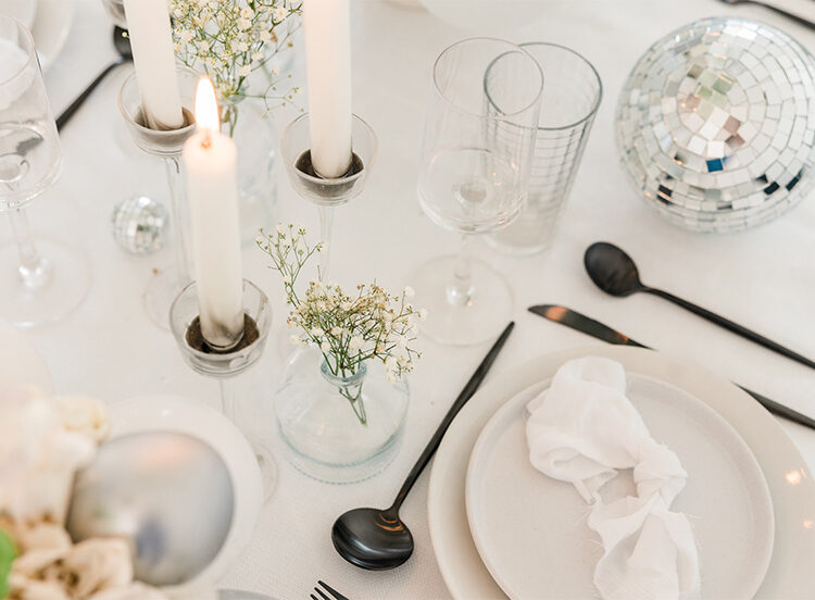 White party table decor with candles and a disco ball